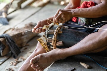 Coseup of a man decorating traditional drum in Siberut island