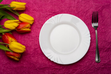 Tulips with a plate on the table. Romantic table. Romantic picture. Tulips with a plate on the table
