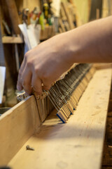 luthier working on the restoration of a piano. Repairing a wooden piano.