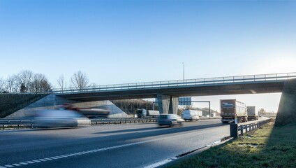 Fototapeta na wymiar Long highway with passing cars under a blue sky in Denmark