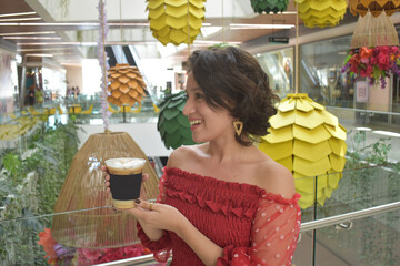 Linda joven sujetando vaso de caf&eacute; helado, producto iced latte 