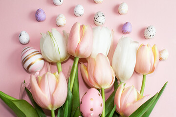 Easter composition of pink and white tulips, ribbon and decorative eggs on a pink background. Tulips bouquet, spring flowers. Content for Easter holiday. Flat lay, top view, close up