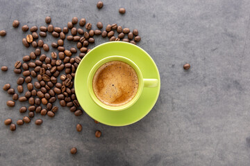 A cup of invigorating coffee and coffee beans. Top down view