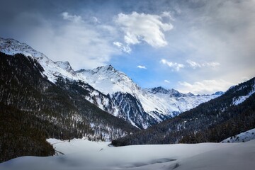 Fototapeta na wymiar Aerial view of snow covered mountain landscape with dense trees