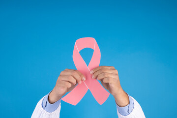 Doctor's hands holding the symbol of fight against breast cancer. concept of fight against cancer