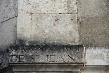 Closeup of grande rue st jean engraving on a gray wall
