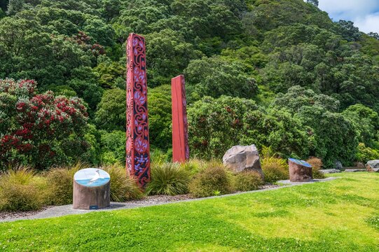 Scenic view of tribal Maori carvings in the Whakatane park surrounded by evergreen hills