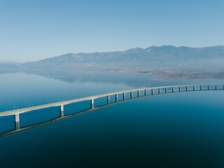 Fototapeta na wymiar Aerial view of the Lake Polyfytos Bridge with a blue sky in the background, Greece