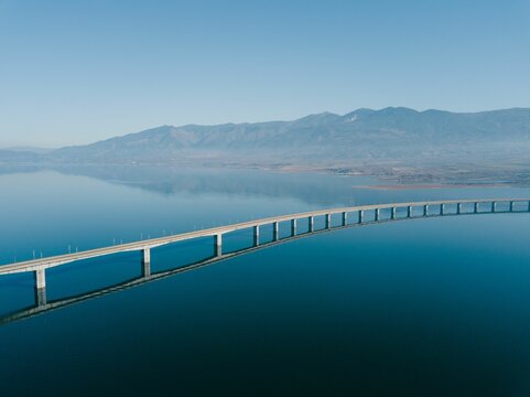 Aerial view of the Lake Polyfytos Bridge with a blue sky in the background, Greece