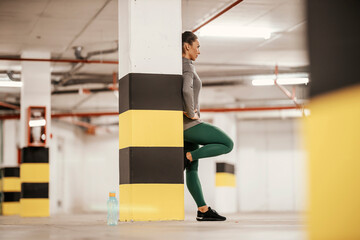 Obraz premium A sportswoman is taking a break after exercising in underground garage.