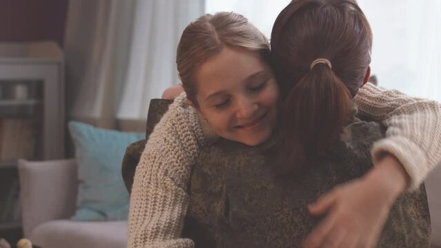 Caucasian military woman returning home to daughter after long army service, embracing in living room