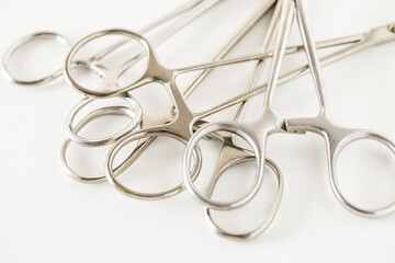 Surgical instruments, metal clamps forceps on white background, selective focus