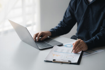 Business man pointing to a pie chart document showing company financial information, He sits in her private office, a document showing company financial information in chart form. Financial concepts