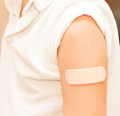 Medical patch glued to shoulder hand of boy child, selective focus