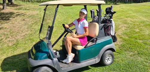 Young beautiful female golfer in golf carts