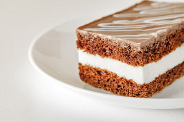 Three-layer chocolate cake on white plate, space to copy text, selective focus