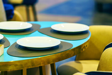 White plates on a blue table and leather stands in the restaurant
