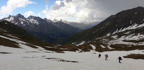 Backpack mountaineers hike from the peaks of the Kaçkar Mountains in Turkey into the depths of the valley