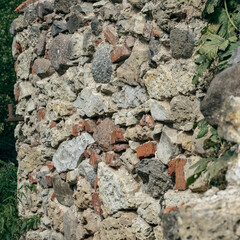 Old stone wall with pebbles and moss. Old stone wall background
