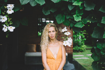 Charming woman in dress standing in garden
