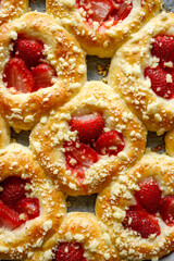 Homemade sweet yeast rolls with addition of strawberries an butter crumble, close up view