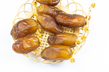 Close-up of Algerian royal dates on a wooden plate on a white background. Ramadan concept.