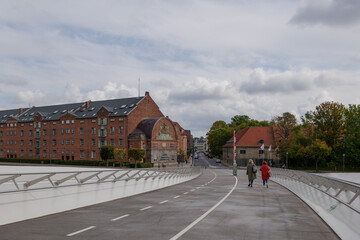 People walk on pedestrian and bicycle bridge Lille Langebro, Little Long Bridge link Langebrogade...