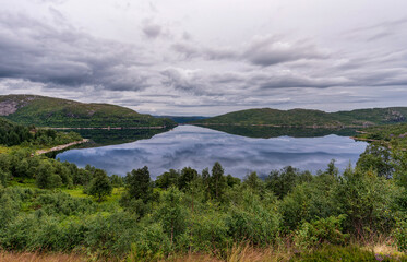 Naklejka na ściany i meble Norway Landscape with Lake and Reflection. Cloudy Blue Sky.