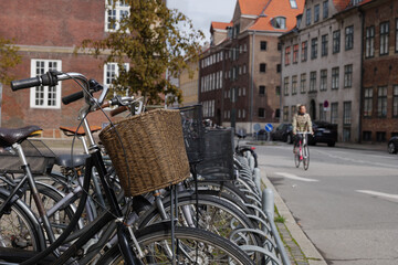 Selective focus at basket in front of bicycle park at cycling park on sidewalk beside street in...