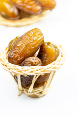 Close-up of Algerian royal dates on a wooden plate on a white background. Ramadan concept.