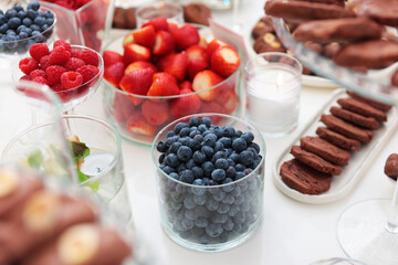 Variety of berries on the table. Cookies and berries on the festive table. Field service at parties. The concept of public catering. Selective focus.