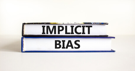 Implicit bias symbol. Concept words Implicit bias on books. Beautiful white table white background. Business psychology implicit bias concept. Copy space.