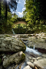 Obraz premium The Astico stream and the ancient stone bridge along the nature trail 