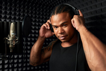 African American at the recording studio in headphones reads rap - obrazy, fototapety, plakaty
