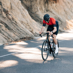 Fototapeta na wymiar Professional cyclist in helmet and glasses riding a road bike