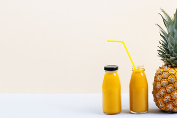 Pineapple and a fresh healthy smoothie in a glass bottles and a straw on a blue background. Healthy, detox and dietary nutrition concept.