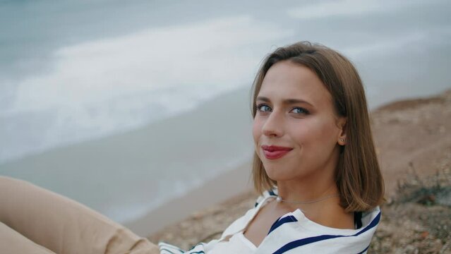 Girl enjoying sea cliff view closeup. Smiling tourist posing resting at ocean