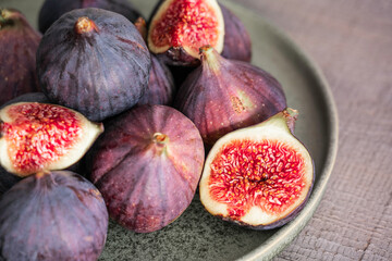 Close-up fresh fig fruit and slices of figs on plate. Heap of tasty organic figs