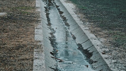 Concrete Trench Drain Filled with Rain Water on Cold Cloudy Day