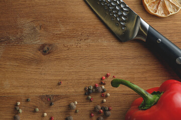 Red bell pepper with spices and kitchen chef knife on cutting board. Space for text . Kitchen concept