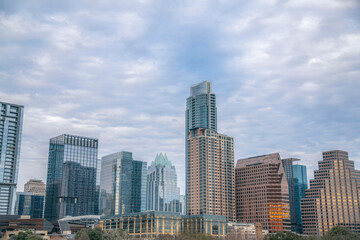 Fototapeta na wymiar Austin, Texas cityscape against the cloudy sky background. Facade of residential and business skyscrapers with reflective glass exterior.