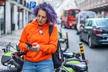Obraz premium Mature Woman With Phone And Electric Bike Instead Of Transportation, Clean Energy Or Sustainable Travel. Technology, Electric Bicycle And Respectful With The Environment.