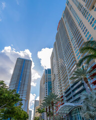 Looking up at exterior of apartments and cloudy blue sky in Miami Beach Florida. View from the ground of modern residential buildings in the city on a beautiful sunny day.