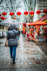 Obraz na płótnie Canvas Une femme marche de dos sous la pluie pendant le nouvel an chinois à Paris, 4 février 2017
