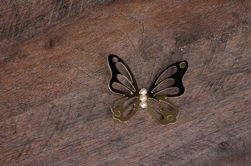 borboleta decorativa dourada em fundo de madeira 