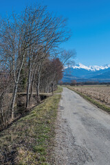Chemin dans la campagne en Is&egrave;re, vue sur les montagnes enneig&eacute;es