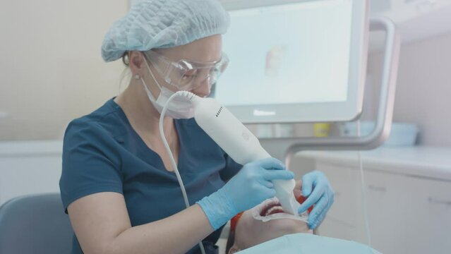 Orthodontist using 3D intraoral scanner for scanning teeth patient's. Modern dental clinic with equipment. Dentistry and health care concept. Jaw scan, digital imprint, medical digital technology.