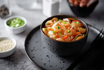 Funchosa with shrimp and vegetables in a plate Pad Thai