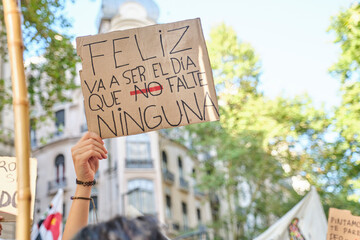 International feminist strike, an unrecognizable woman holds up a sign with the text Happy will be the day that none of us will be missing. - obrazy, fototapety, plakaty
