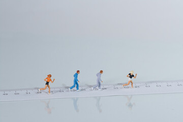 joggers, runners run along a tape measure, light background. Concept: fitness and health through sport